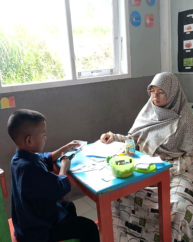 Anak berlatih motorik halus bersama pendamping